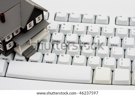 A model house sitting on a computer keyboard, online real estate