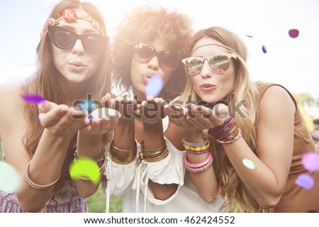 Girls blowing some confetti pieces Royalty-Free Stock Photo #462424552