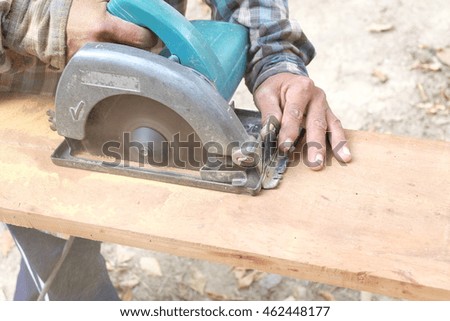 carpenter cutting a wooden plank