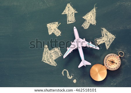 top view photo of toy airplane over chalkboard background and arrows drawings. filtered image