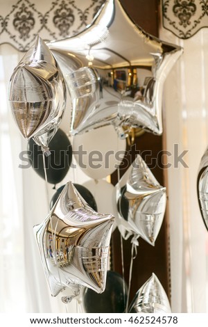 A closeup of silver balloons in the form of stars