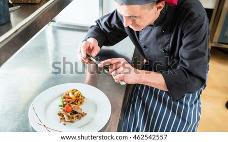 Chef making picture of food he cooked with phone