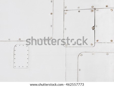 Vintage background. White metal airframe surface divided into rectangular pieces and connected with rivets. Place for an inscription. Royalty-Free Stock Photo #462557773