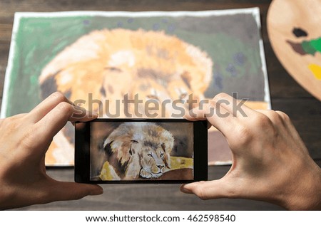 Photos picture of a lion on the phone. Drawing on the background, mobile in hand.