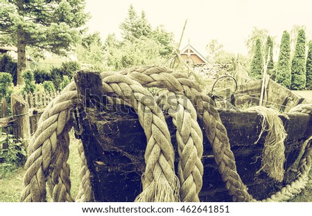 Detail of old wooden fishing boat with ropes and fishing net. Vintage filter effect