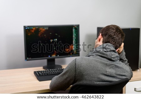 bored male gamer playing video games on computer - stock photo