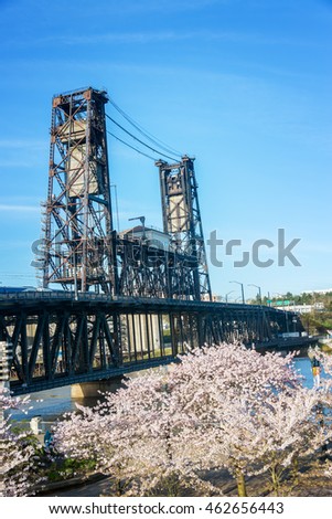 Vertical view of blooming cherry blossoms and the Steel Bridge in Portland, Oregon