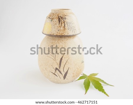 Beautiful sake (hot rice wine) cup and bottle, maple, on bright white background