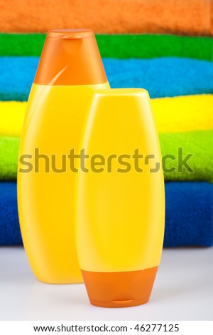 Bottles of shampoo and colour terry towels on white background.  isolated
