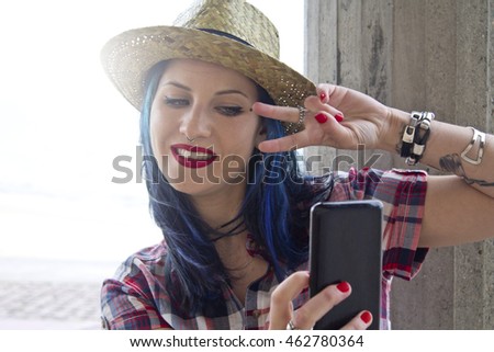 young woman with hat becoming a selfie