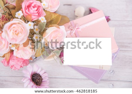 Picture of gift box with red ribbon with flower and gift card on wood background. congratulation concept