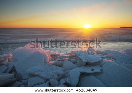 Winter landscape with frozen lake and sunset sky. Composition of nature.

