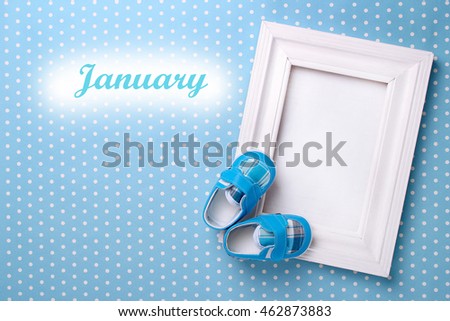 baby's bootees with a frame on a blue background