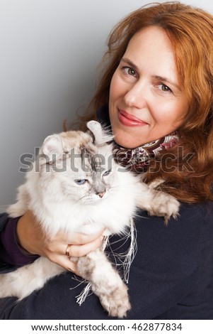 Portrait of beautiful smiling Young Caucasian woman with white cat in hands