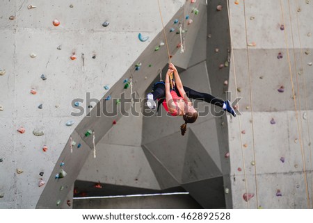 Beautiful sporty girl is training in bouldering gym