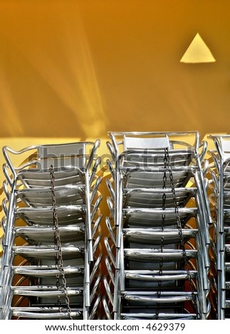 metallic chairs on yellow background with sun reflection in spain