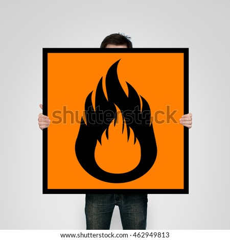 Man holding flammability warning poster