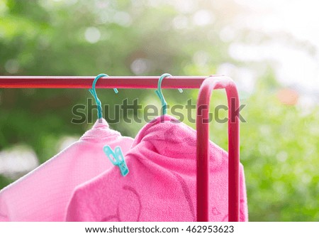 Selective focus Two pink towel outside the house and blurred background of green tree in nature light.