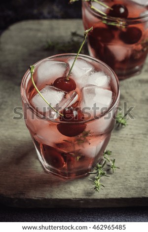 berry juice with ice and herbs. wooden table f rustic style. toned image