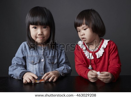 Two Asian Chinese child,Sisters and friends,playing in studio
