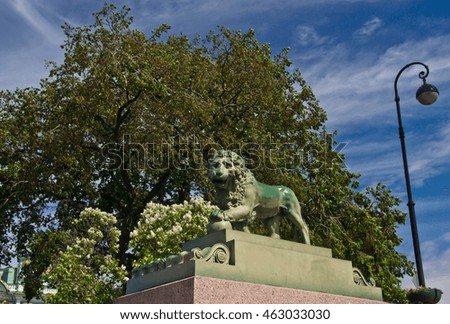 lion monument on the street under a big tree