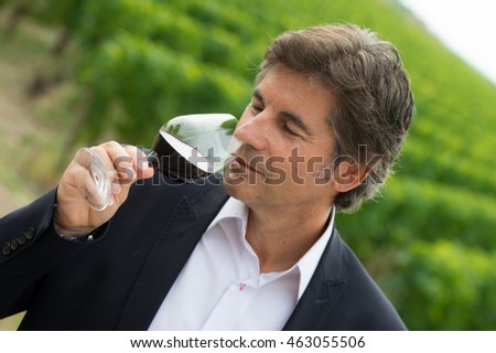 Portrait confidant vintner drinking red wine in winery cellar