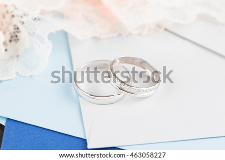 Wedding rings in white gold on envelope and lace background. Bride ring with diamonds. Shallow focus