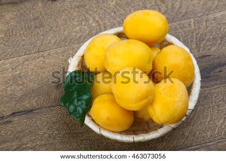 Fresh ripe sweet yellow apricots on the wood background