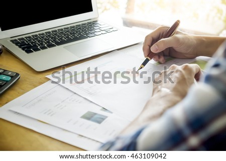 Business man hand pointing at business document during discussion at meeting