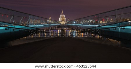 Nighttime image showing the view from the South bank of Thames River in London, England.  St Paul's Cathedral is visible at far end of the Millennium Bridge.