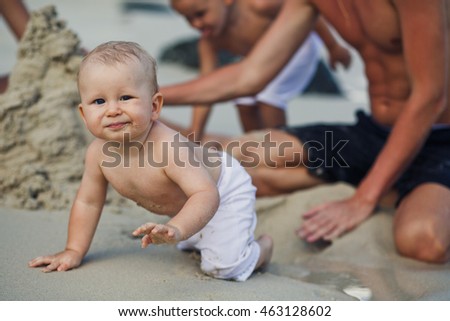The parents with sons play on the beach
