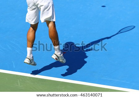 Tennis player serves the ball (shadow of player on the hard court) Royalty-Free Stock Photo #463140071