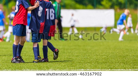 Young football players on the pitch. Grass sports field. Horizontal youth soccer picture.