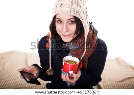 Woman enjoying a large cup of freshly brewed hot tea as she relaxes on a sofa in the living room.