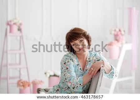 bright and emotional woman with blue eyes in a blue dress with gently pink flowers