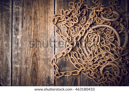 Tangle of rusty chains on wooden boards with copy space
