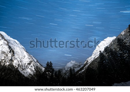 Circular stars in the night sky in winter mountains