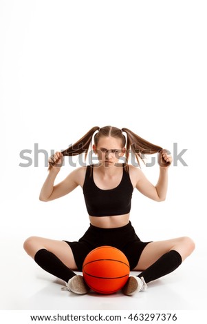 Young pretty girl posing with basketball over white background.