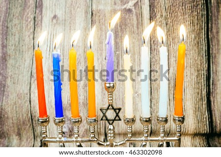 low key image of jewish holiday Hanukkah with menorah traditional Candelabra and wooden dreidels spinning top . glitter overlay