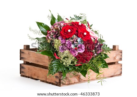 bouquet of red roses decorated with flowers on wooden box
