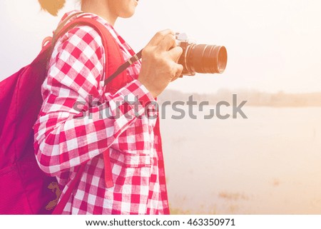 young woman girl is travel with backpack and handle camera of take photosin pastel or vintage style color. travel concept copy space background