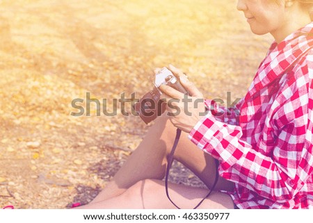Tourist young woman holding vintage old photo camera in outdoor