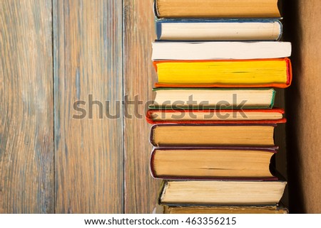 Colorful composition with vintage old hardback books, diary on wooden deck table and wood background. Books stacking. Back to school. Copy Space. Education background