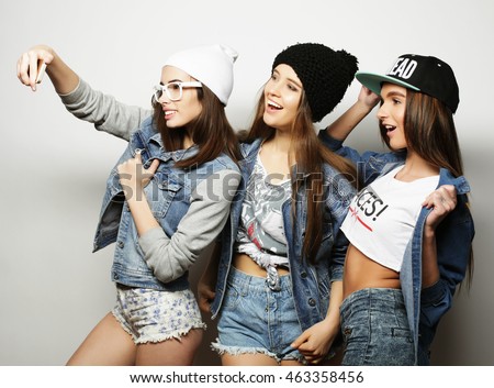 three happy teenage girls with smartphone taking selfie