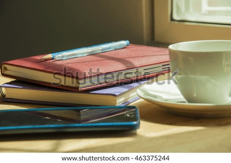 Morning coffee on wooden background. Notebooks, pens, pencils