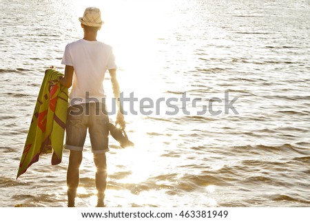 young man on the beach watching the sea at sunset summer