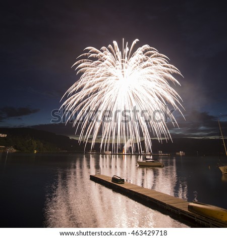 Ignis Brunensis silver and gold colored firework resembling aster flower after sun set blue sky above dam. Long exposure night graphical photography using creative tilt effect by tilt-shift lens.
