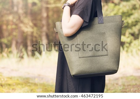 khaki color felt bag on woman's shoulder Royalty-Free Stock Photo #463472195