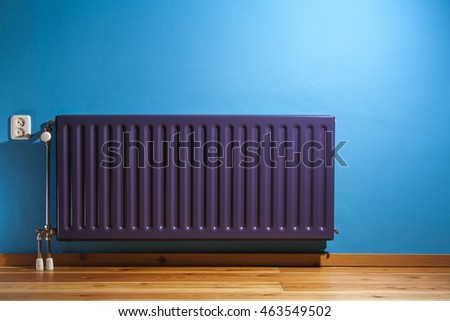 Purple central heating radiator and a blue wall with power point in the Netherlands