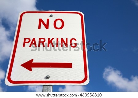 No Parking Sign with Arrow Pointing Left Frame Left against Blue Sky with Clouds
